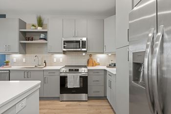 A modern kitchen with stainless steel appliances and white cabinets.